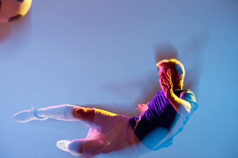 Jalkapalloilija ilmassa potkaisemassa palloa